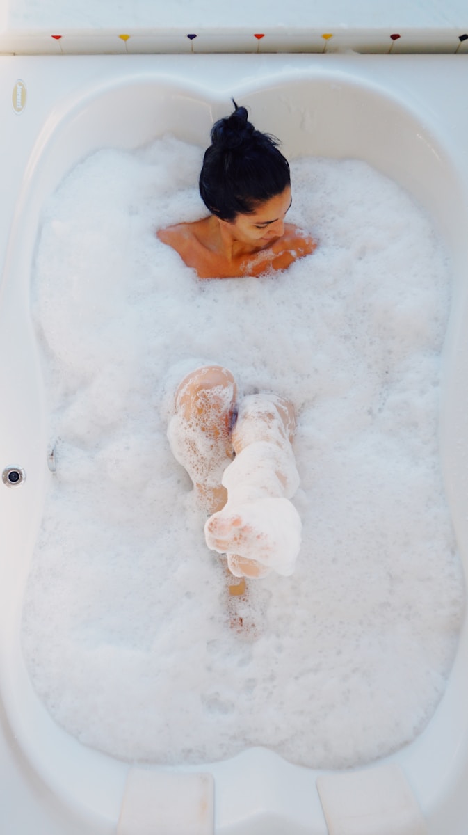 photography of woman on bathtub covered with white bubbles Self Care is health care